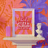Retro-style poster with psychedelic 1970s-inspired design. Text reads "WEIRD GIRLS DO IT BETTER" in wavy, groovy lettering. Pink and orange sunburst background. Centered text surrounded by curved rays. Bold red frame with scalloped edges. Vibrant colors and playful typography create a vintage hippie vibe. Square format print with rounded corners. Perfect for fans of retro aesthetics and empowering slogans.